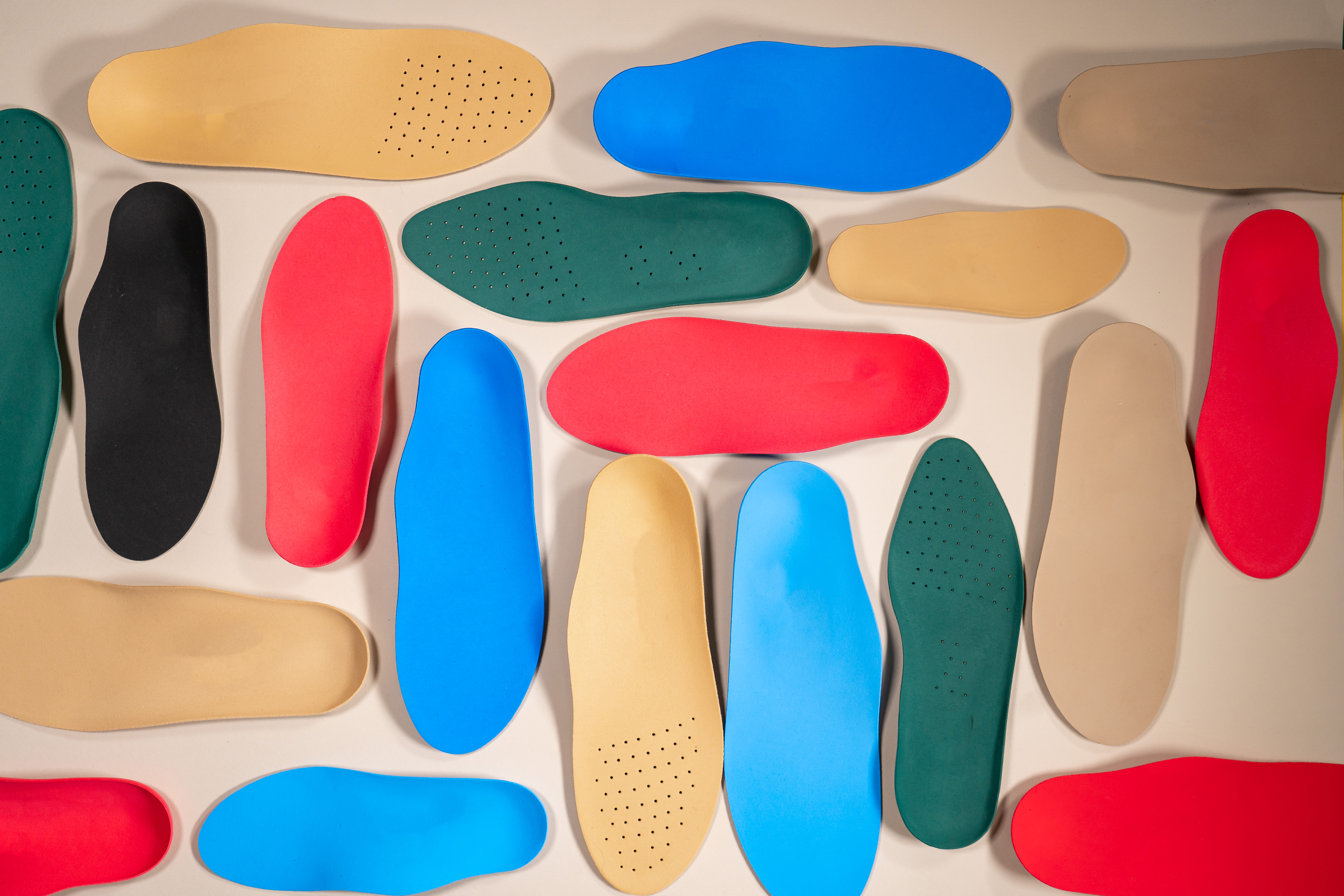 Footwear insoles and material samples on a wooden surface — technical material development